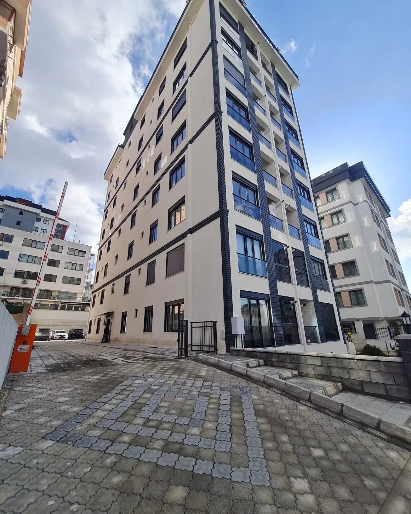 NES Park Evleri’nin taş döşeli avludan görünümü; bina girişi ve çevre düzenlemesi